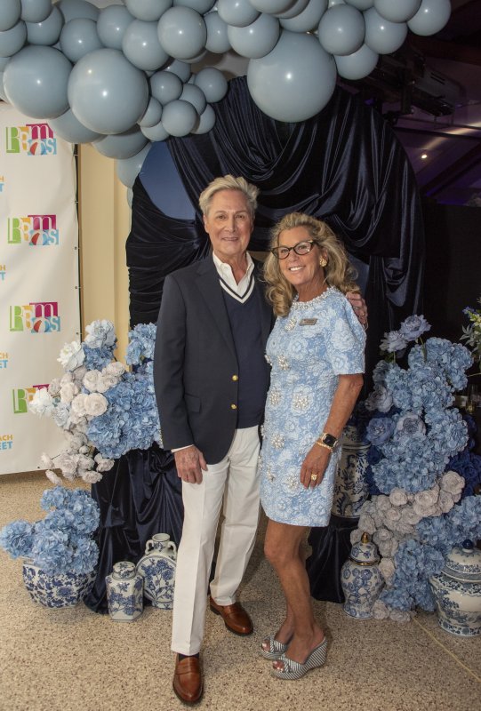 Cliff Martell, fashion show director, and Jen Carroll, event chair, pose with the balloon wall.